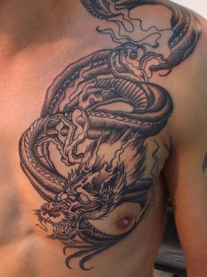 Photo de dragon asiatique au pec, dragon, tatouage réalisé par Bodygraphic