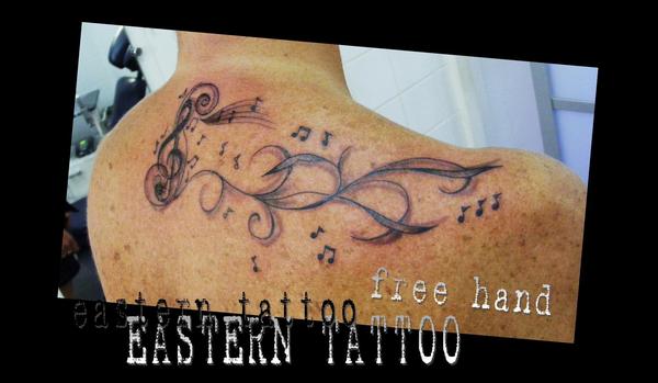 Photo de Clé de sol et arabesques, tatouage, inclassable réalisé par Eastern Tattoo