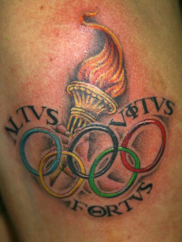 Photo de flamme et anneaux olympique, écriture, tatouage réalisé par Bodygraphic